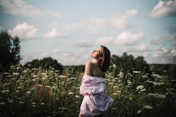 A woman walks through a field of tall grass in summer