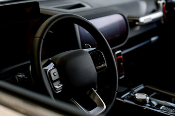 Modern car interior with steering wheel and dashboard display visible