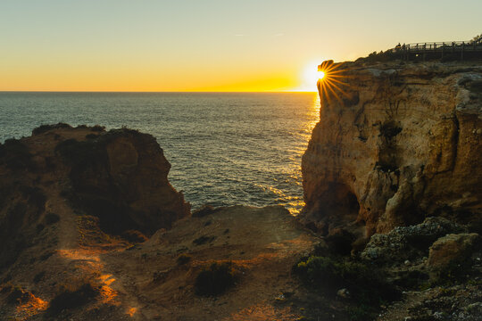 Sunburst over cliffs at sunset in Carvoeiro