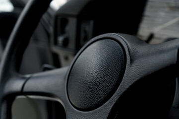 Obraz premium Close-up of black leather steering wheel inside vehicle cabin