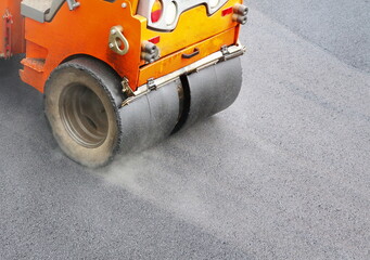 Roadwork road roller at hot asphalt