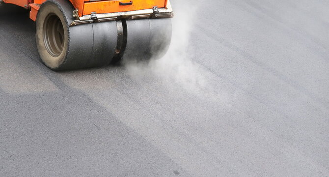 Roadwork road roller at hot asphalt