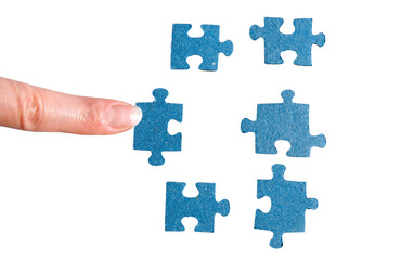 Fototapeta premium A finger adds a blue jigsaw piece. A hand holding a puzzle piece.