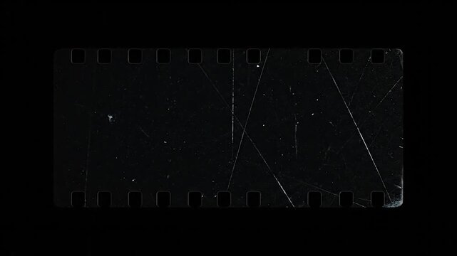 A weathered strip of 35mm film lies against a black backdrop, scratches & imperfections present