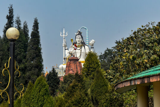 Giant Lord Shiva statue at The Char Dham temple complex in Namchi, colorful architecture under clear blue sky.