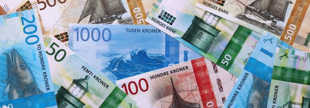 Norwegian krone money bills pile on table. Norway banknotes of NOK currency close up.
