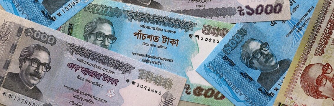 Bangladeshi taka money bills pile on table. Bangladesh banknotes of BDT currency close up.