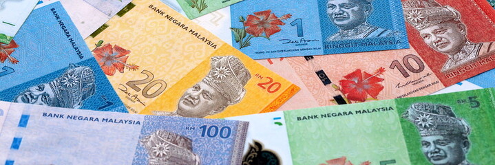 Malaysian ringgit money bills pile on table. Malaysia banknotes of MYR currency close up. © Larysa