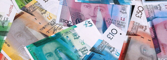Gibraltar pound money bills pile on table. Gibraltar banknotes of GIP currency close up.