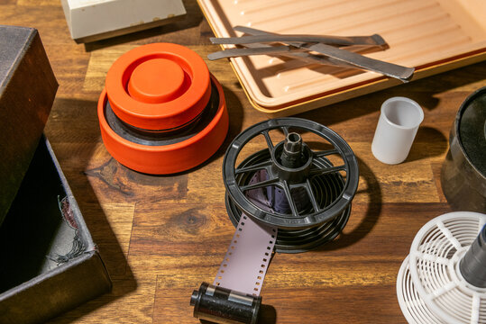 Equipment for analog photography, developing tray and film roll.