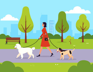 Fototapeta premium A woman in a red dress walks two dogs, a white poodle and a spotted dog, on leashes through a vibrant green park with a city skyline in the background.