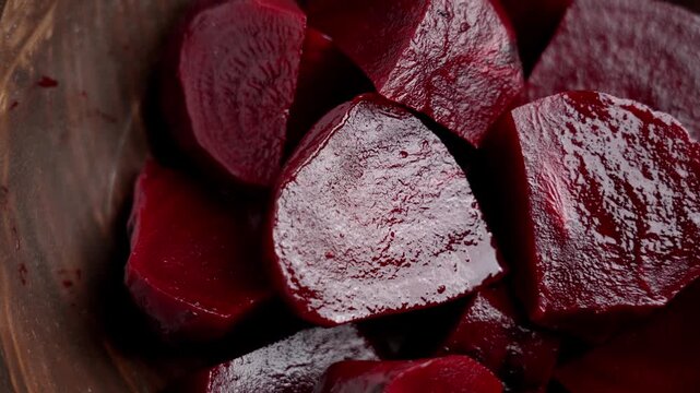 Sliced ​​boiled peeled beetroot chunks in a wooden bowl. Natural cooked root. Dietary salad ingredient