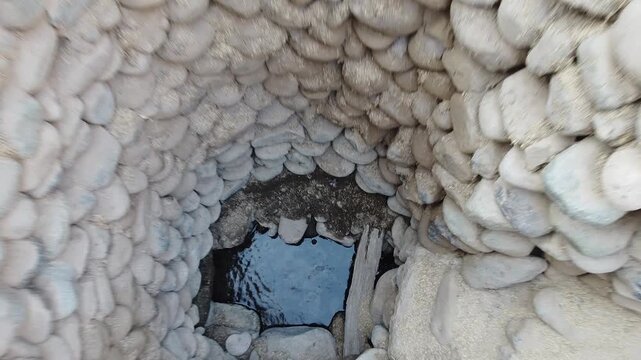 Detailed vertical view of the stone-lined spiral wells (puquios) capturing groundwater in the arid Nasca valley.