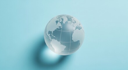 Fototapeta premium Glass globe showing continents on a light blue background