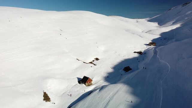 Ski slope in the French Alps, next to a chalet. Aerial footage