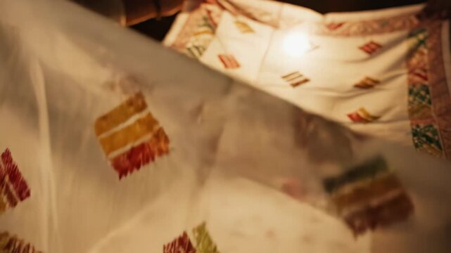 Close Up Of White Fabric With Colorful Geometric Patterns And Intricate Border Designs Illuminated By Warm Soft Light Displaying Traditional Craftsmanship And Cultural Heritage
