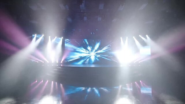 Modern concert stage with blue lights and screens showing dynamic visual effects for live performance or event