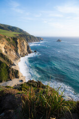 Fototapeta premium Scenic view on ocean and beach at sunset along Pacific Ocean near Bixby Bridge .travel, vacation, tourism vertical banner .