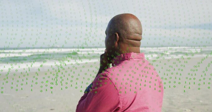 Senior man pink shirt musing on shore, panning revealing face while binary sweeping reflecting tech