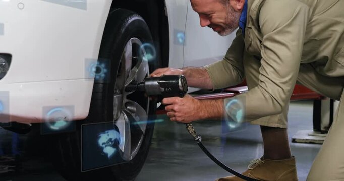 Male technician kneeling in automotive bay, positioning impact wrench and verifying torque with HUD