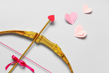 Naklejka premium Composition with cupid's bow and paper hearts on grey background. Valentine's Day celebration
