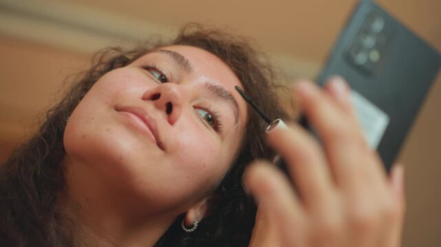Selfassured lady makes final beauty adjustments. Calm woman finetunes eyebrows before her significant appointment. Poised lady in hotel finalizes her appearance to impress at meeting