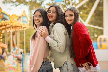 Fototapeta premium Happy teenage girls hugging in amusement park