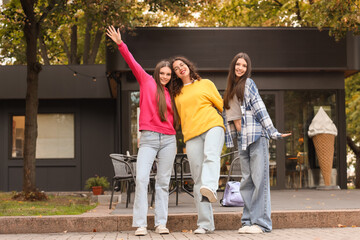 Happy teenage girls hugging in park