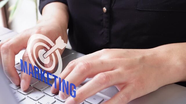 Close-up of female hands typing on a laptop with an animated target displaying the word "Marketing". Marketing objectives.