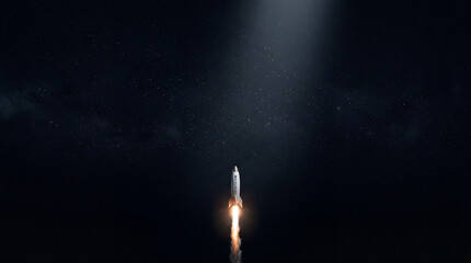 Fototapeta premium A powerful rocket launches upwards into a dark, star-filled night sky
