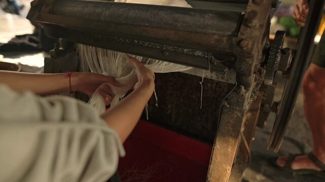 Careful Artisan Shapes Delicate Rice Strands. Skilled Worker Arranges Rice Noodles With Precision. Dedicated Worker Expertly Collects And Arranges Rice Noodles Into Orderly Stacks For Drying