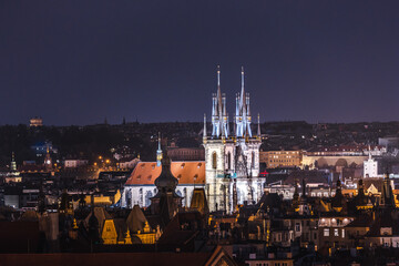 Obraz premium Evening panorama of Prague Old Town with glowing gothic towers of Church of Our Lady before Tyn above historic city roofs in Czech Republic