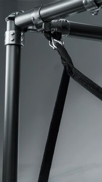 Rebounder Net Detail. Football Training Equipment Mockup (Functional & Educational). Functional Mockup. A close-up of a black bungee-cord tensioned on a rebounder net frame, set in a minimalist studio