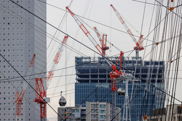 帆船日本丸のロープ越しに望む横浜の都市開発とタワークレーン