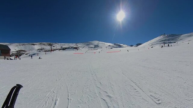 4K Time-lapse of the Veleta peak slopes in Sierra Nevada, Spain, showing the movement of shadows and skiers across the vast snowy mountain during a sunny day
