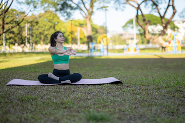 Fototapeta premium Woman practicing yoga stretching outdoors in park