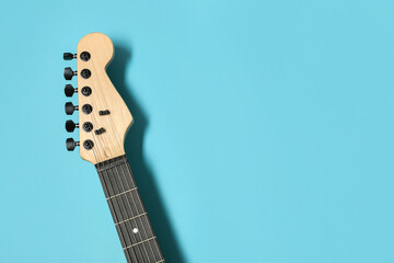 Modern electric guitar on blue background, closeup