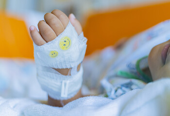 Kid patients have IV tube child's hand Children's patient in the hospital with saline intravenous (iv) was punctured with an IV needle by a doctor