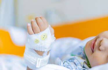 Kid patients have IV tube child's hand Children's patient in the hospital with saline intravenous (iv) was punctured with an IV needle by a doctor