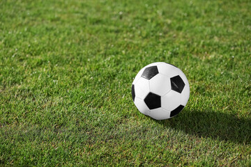 Fototapeta premium Soccer ball on green stadium grass, closeup