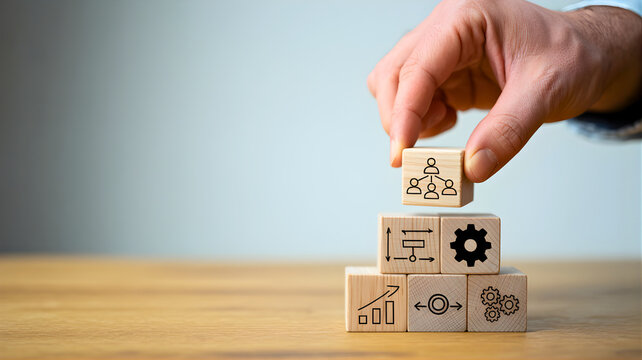 Hand placing wooden block with icon on stack on wooden table