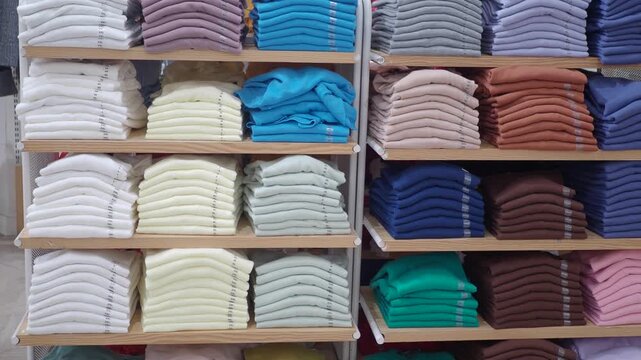 Neatly folded stacks of colorful sweaters arranged on store shelves