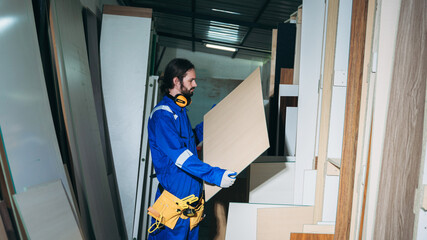 Professional Woodworker Measuring, Cutting and Installing Timber in Factory. Carpentry and Wood Manufacturing Process in Industrial Workshop