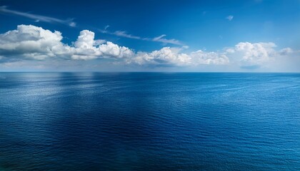 Obraz premium Cloudy Blue Sky Above A Blue Surface Of The Sea