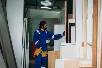 Professional Woodworker Measuring, Cutting and Installing Timber in Factory. Carpentry and Wood Manufacturing Process in Industrial Workshop