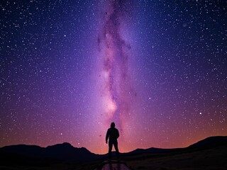 Fototapeta premium Solo traveler atop mountain, Milky Way above, star-gazing achievement, solo, night sky