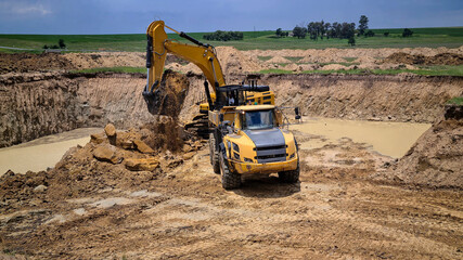 Obraz premium View of earthworks for foundations with heavy construction machinery