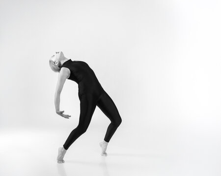 Mujer actuando y bailando sobre un piso blanco y ropa negra