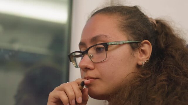 Relaxed learner reviewing notes during commute. Satisfied pupil reflecting on material while traveling home. Content student leisurely studying notes with gentle smile during train journey