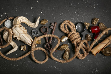 Sheep scull with travel equipment, smoking pipe and golden nuggets on grunge black background © Pixel-Shot